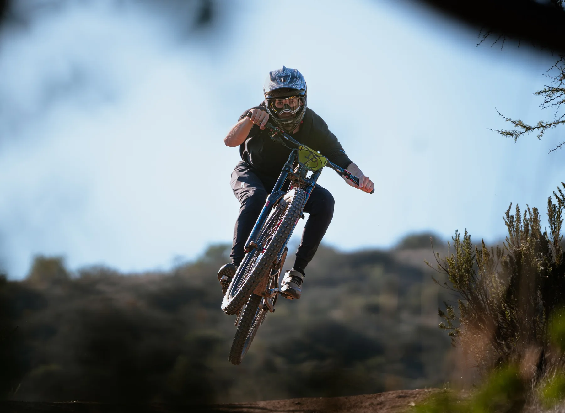 Ciclista de downhill saltando hacia la cámara