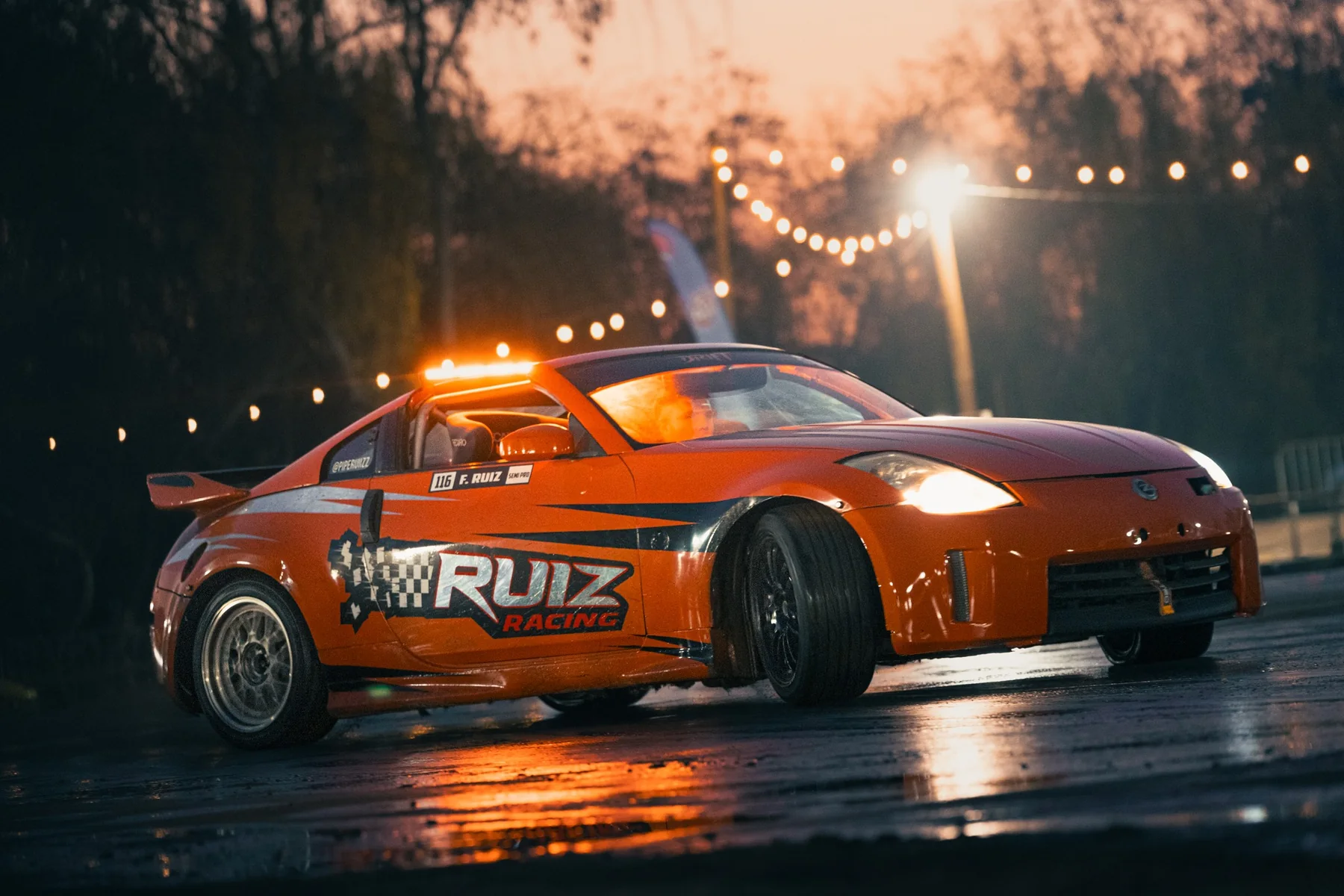Auto de drift derrapando sobre pista mojada