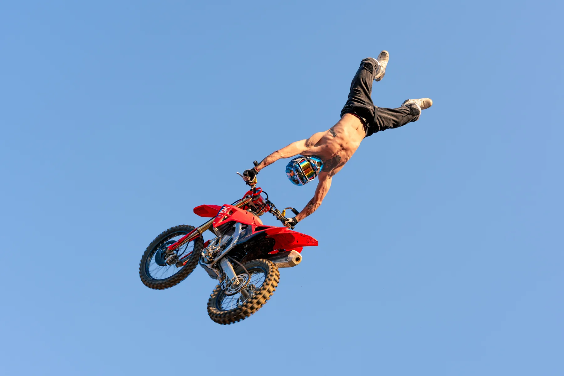 Piloto de freestyle motocross ejecutando una maniobra aérea